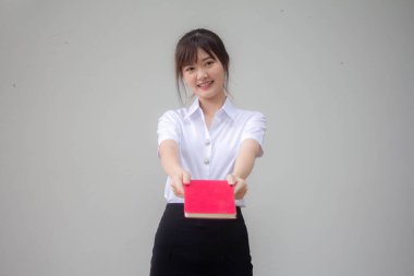 Taylandlı yetişkin öğrenci üniforması güzel kız kırmızı kitap gösteriyor.