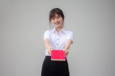 Taylandlı yetişkin öğrenci üniforması güzel kız kırmızı kitap gösteriyor.