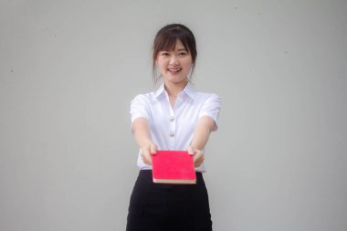 Taylandlı yetişkin öğrenci üniforması güzel kız kırmızı kitap gösteriyor.