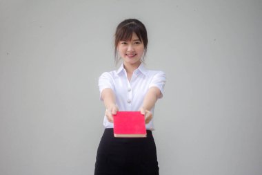 Taylandlı yetişkin öğrenci üniforması güzel kız kırmızı kitap gösteriyor.