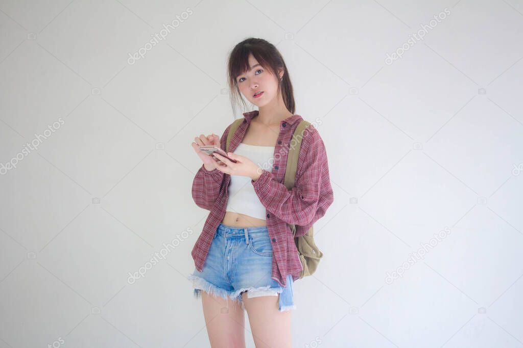 Beautiful Thai girl tourists scottish White shirt blue jeans using her smart phone