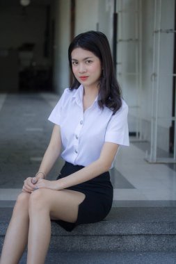 Taylandlı yetişkin öğrenci üniforması güzel kız rahatla ve gülümse.