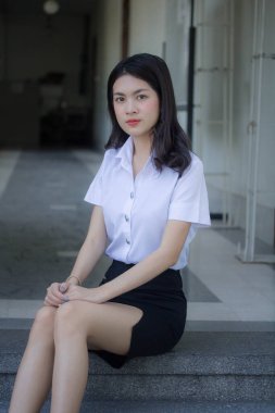 Taylandlı yetişkin öğrenci üniforması güzel kız rahatla ve gülümse.