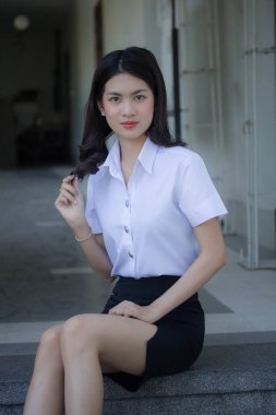 Taylandlı yetişkin öğrenci üniforması güzel kız rahatla ve gülümse.