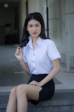 Taylandlı yetişkin öğrenci üniforması güzel kız rahatla ve gülümse.