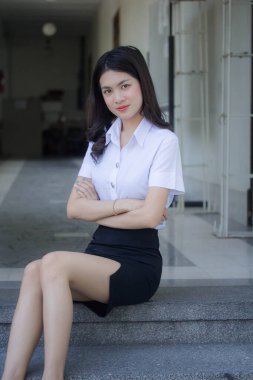 Taylandlı yetişkin öğrenci üniforması güzel kız rahatla ve gülümse.