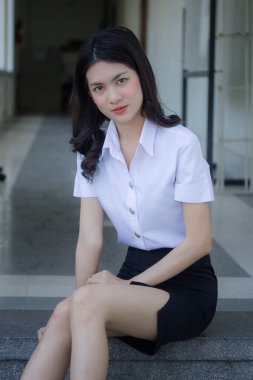 Taylandlı yetişkin öğrenci üniforması güzel kız rahatla ve gülümse.