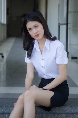 Taylandlı yetişkin öğrenci üniforması güzel kız rahatla ve gülümse.