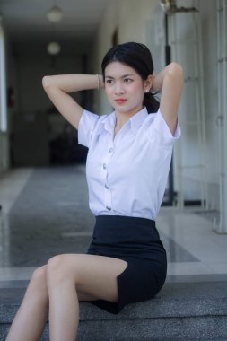 Taylandlı yetişkin öğrenci üniforması güzel kız rahatla ve gülümse.