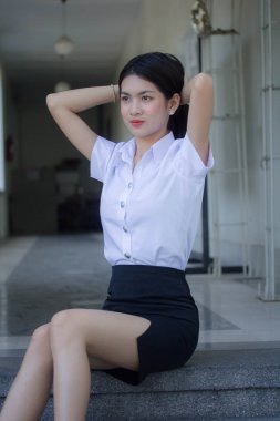 Taylandlı yetişkin öğrenci üniforması güzel kız rahatla ve gülümse.