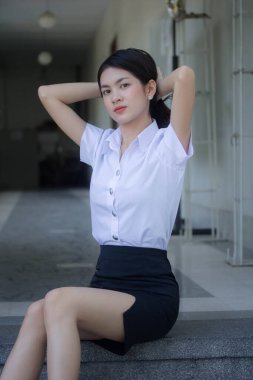 Taylandlı yetişkin öğrenci üniforması güzel kız rahatla ve gülümse.