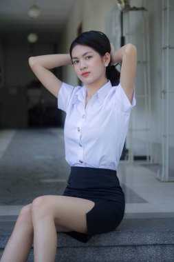 Taylandlı yetişkin öğrenci üniforması güzel kız rahatla ve gülümse.