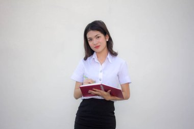 Taylandlı yetişkin öğrenci üniforması güzel kız. Kitap yaz.