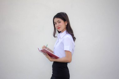 Taylandlı yetişkin öğrenci üniforması güzel kız. Kitap yaz.