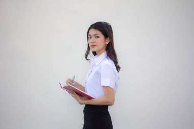 Taylandlı yetişkin öğrenci üniforması güzel kız. Kitap yaz.