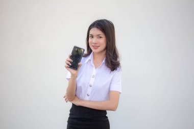 Taylandlı yetişkin üniversite üniforması güzel kız akıllı telefonunu göster.