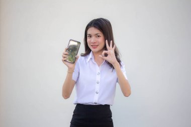 Taylandlı yetişkin üniversite üniforması güzel kız akıllı telefonunu göster.