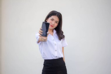 Taylandlı yetişkin üniversite üniforması güzel kız akıllı telefonunu göster.