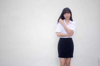 Taylandlı yetişkin öğrenci üniforması güzel kız rahatla ve gülümse.