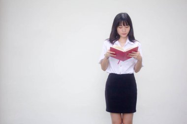 Taylandlı yetişkin üniversite üniforması güzel kız kırmızı kitabı okuyor.