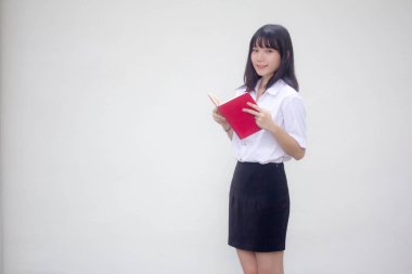 Taylandlı yetişkin üniversite üniforması güzel kız kırmızı kitabı okuyor.