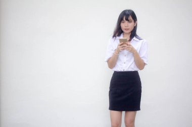 Yetişkin öğrenci üniforması. Akıllı telefonunu kullanan güzel bir kız.