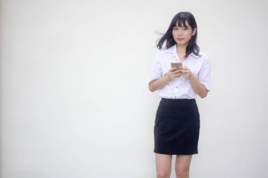 Yetişkin öğrenci üniforması. Akıllı telefonunu kullanan güzel bir kız.