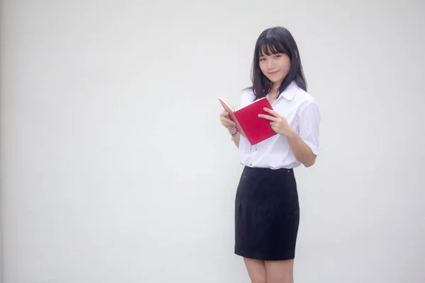 泰族成人大学生校服漂亮女孩读红皮书 — 图库照片