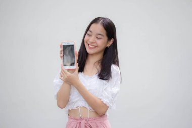 Asya Taylandlı genç Japon Tişörtlü güzel kız Telefonunu göster ve gülümse