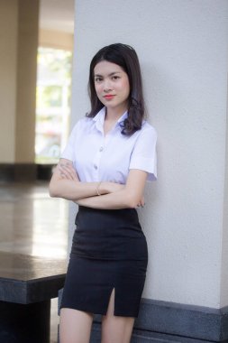 Taylandlı yetişkin öğrenci üniforması güzel kız rahatla ve gülümse.