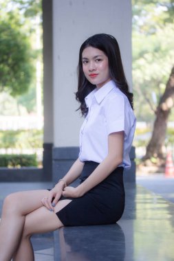 Taylandlı yetişkin öğrenci üniforması güzel kız rahatla ve gülümse.