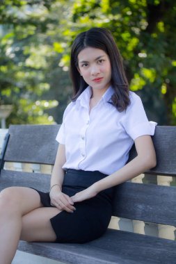 Taylandlı yetişkin öğrenci üniforması güzel kız rahatla ve gülümse.