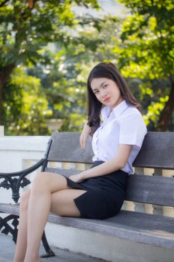 Taylandlı yetişkin öğrenci üniforması güzel kız rahatla ve gülümse.