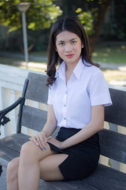 Taylandlı yetişkin öğrenci üniforması güzel kız rahatla ve gülümse.