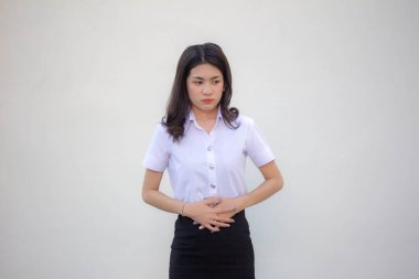 Taylandlı yetişkin üniversite üniforması güzel bir kızın karnı ağrıyor.