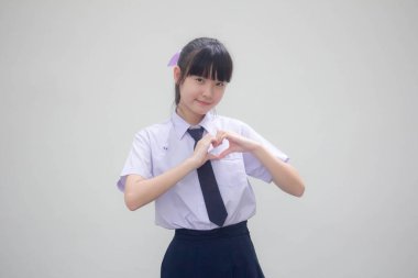 Taylandlı liseli üniformasının portresi. Güzel bir kız kalbini verir.