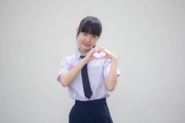 Taylandlı liseli üniformasının portresi. Güzel bir kız kalbini verir.