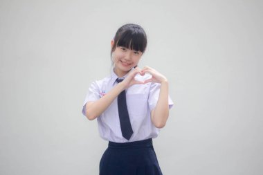 Taylandlı liseli üniformasının portresi. Güzel bir kız kalbini verir.