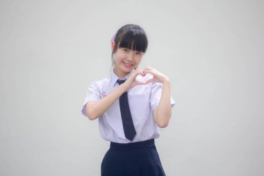 Taylandlı liseli üniformasının portresi. Güzel bir kız kalbini verir.