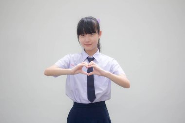 Taylandlı liseli üniformasının portresi. Güzel bir kız kalbini verir.