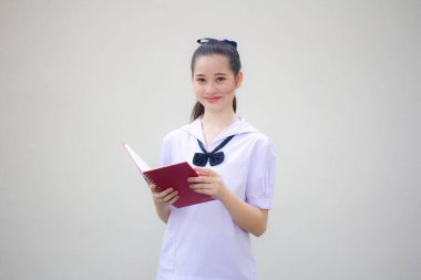 Asya thai ortaokul üniforması güzel kız bir kitap okudu.