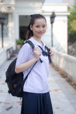 Asya Thai ortaokulu öğrencisi üniforması güzel kız gülümse ve rahatla