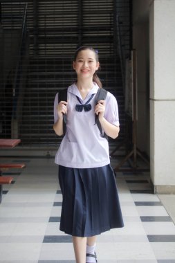 Asya Thai ortaokulu öğrencisi üniforması güzel kız gülümse ve rahatla