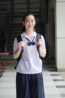 Asya Thai ortaokulu öğrencisi üniforması güzel kız gülümse ve rahatla