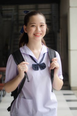Asya Thai ortaokulu öğrencisi üniforması güzel kız gülümse ve rahatla