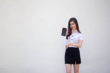 Taylandlı yetişkin üniversite üniforması güzel kız telefonunu göster ve gülümse.