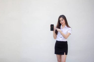 Taylandlı yetişkin üniversite üniforması güzel kız telefonunu göster ve gülümse.