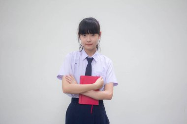 Asya Thai ortaokulu öğrencisi üniforması güzel bir kız ve bir kitap.