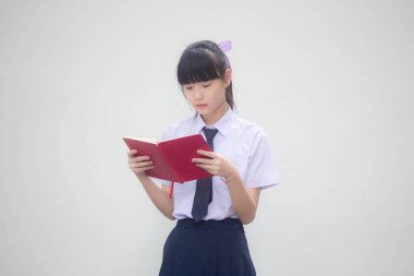 Asya thai ortaokul üniforması güzel kız bir kitap okudu.