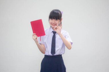 Asya Thai Ortaokulu öğrencisi üniforması Güzel kız bir kitap göster